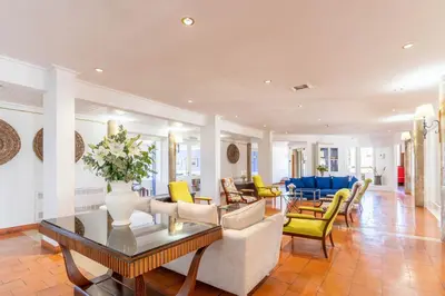 a living room with a vase of flowers on a table at Hotel da Aldeia - Adults Only in Albufeira