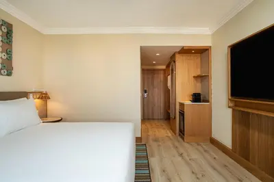a living room with a couch and a flat screen tv at Hyatt Regency Vilamoura Algarve in Vilamoura
