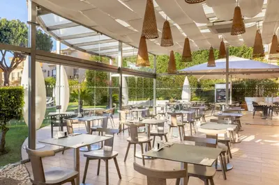 an empty restaurant with tables and chairs and umbrellas at Quinta Pedra Dos Bicos in Albufeira