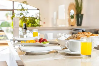 a breakfast table with breakfast foods and orange juice at Clube Maria Luisa in Albufeira