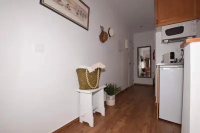 a kitchen with a white refrigerator and a table with a plant at Cosy and Sweet Apartment in Albufeira in Albufeira