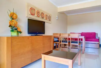 a living room with a television and a table and chairs at Choromar Apartments in Albufeira