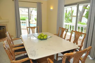 a dining room table with a bowl of fruit on it at Vale Do Garrao Villas in Vale do Lobo
