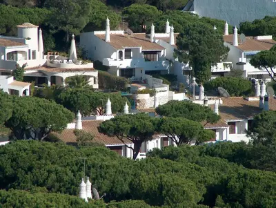 a bunch of houses on a hill with trees at Vale Do Garrao Villas in Vale do Lobo