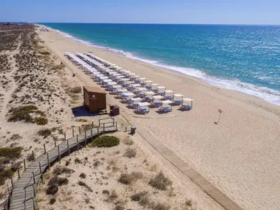 an overhead view of a beach with umbrellas and the ocean at Vale Do Garrao Villas in Vale do Lobo