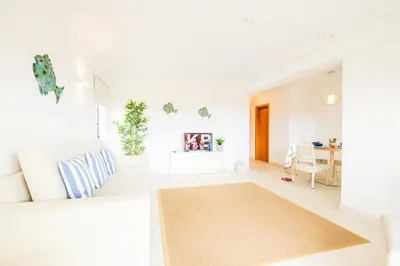 a resort pool with lounge chairs and an umbrella at Apartamentos Turisticos Novochoro in Albufeira