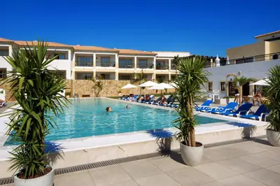 a large building with palm trees in front of it at Apartamentos Turisticos Novochoro in Albufeira
