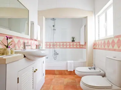 a bathroom with two toilets and a sink and a tub at Cegonha Country Club in Vilamoura