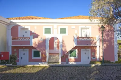 a large house with pink and white at Cegonha Country Club in Vilamoura