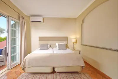 a bedroom with a bed and a large window at Cegonha Country Club in Vilamoura