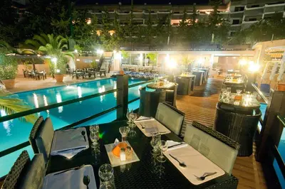 a restaurant next to a swimming pool at night at Hotel Balaia Mar in Albufeira