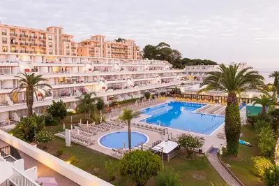 a table and chairs on a balcony with an umbrella at Muthu Clube Praia da Oura in Albufeira