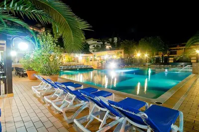 a swimming pool with blue chairs next to a resort at Apartamentos da Balaia in Albufeira