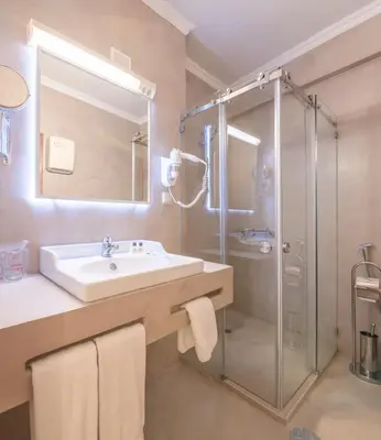 a bathroom with a sink and a shower at Loule Jardim Hotel in Loulé