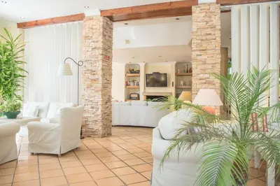 a living room with white furniture and a brick wall at Loule Jardim Hotel in Loulé