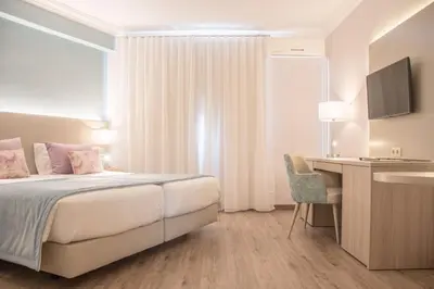 a hotel room with a bed and a desk at Loule Jardim Hotel in Loulé