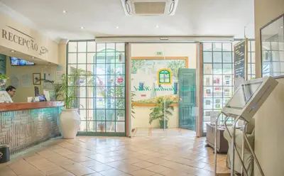 a entrance to a restaurant with a glass door at Loule Jardim Hotel in Loulé