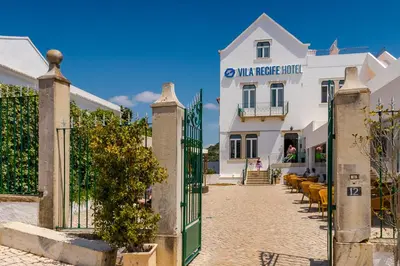 a gate to a white building with a fence at Vila Recife Hotel in Albufeira