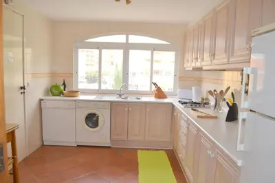 a kitchen with a washing machine and a window at TP Aqua Marina, Vilamoura Triplex Apartment in Quarteira