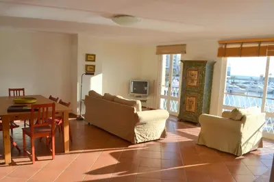 a living room with a table and chairs and a dining room at TP Aqua Marina, Vilamoura Triplex Apartment in Quarteira