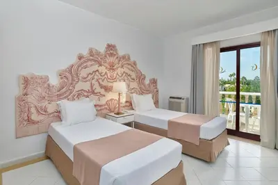 a hotel room with two beds and a balcony at Hotel Apartamento Do Golfe in Vilamoura