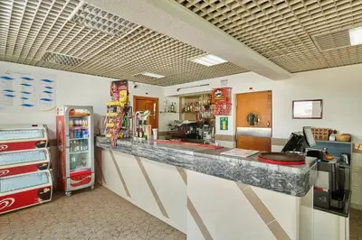 a fast food restaurant with a counter and a refrigerator at Hotel Apartamento Do Golfe in Vilamoura