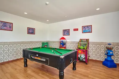 a room with a pool table and two arcade games at Hotel Apartamento Do Golfe in Vilamoura