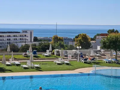 a swimming pool with a view of the ocean at Hotel Apartamento Brisa Sol in Albufeira