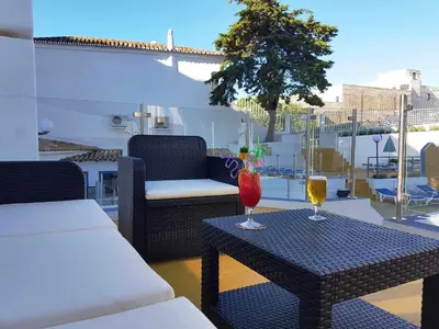 a patio with two glasses of wine on a table at Apartamentos Turisticos Soldoiro in Albufeira