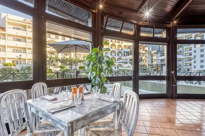 a hotel room with a table and chairs and a bed at Ondamar Hotel Apartamentos in Albufeira