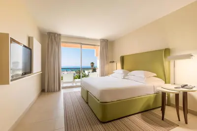 a hotel room with a bed and a large window at NAU Sao Rafael Suites - All Inclusive in Albufeira