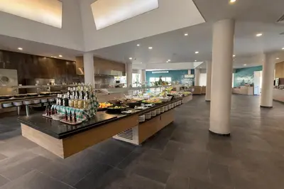 a restaurant with a buffet line with people in the background at AP Adriana Beach Resort in Albufeira