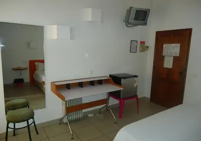 a room with a bed and a desk and a tv at Torre Velha AL in Albufeira