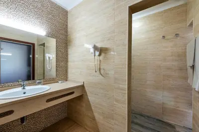 a bathroom with a sink and a mirror at Hotel Pinhal do Sol in Quarteira
