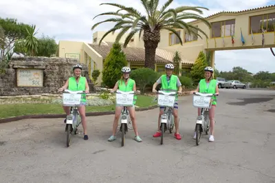 three girls in green shirts sitting on their bikes at Hotel Pinhal do Sol in Quarteira