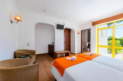 a bedroom with a bed with two towels on it at Hotel Pinhal do Sol in Quarteira