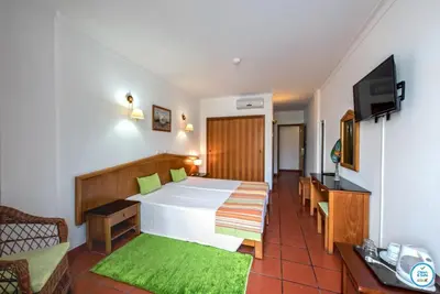 a bedroom with a large bed and a television at Colina do Mar in Albufeira