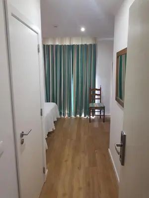 a room with a bedroom with a bed and a chair at Frentomar in Albufeira