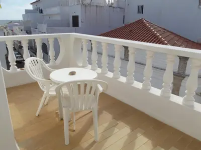 a white balcony with two chairs and a table at Frentomar in Albufeira