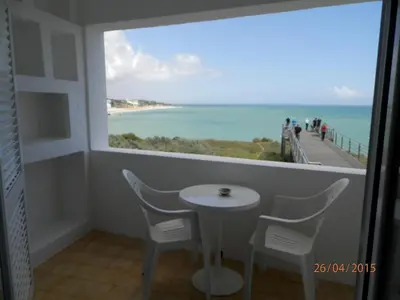 a table and chairs in a balcony with a view of the ocean at Frentomar in Albufeira