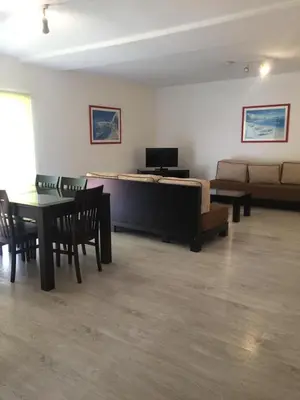 a living room with a couch and a table and chairs at Parque Mourabel, Oásis Village & Pé do Lago in Vilamoura