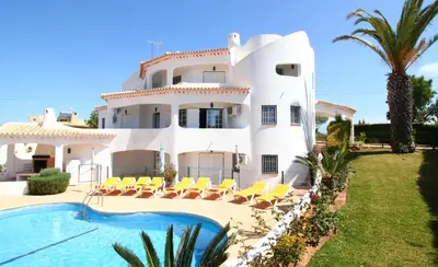 a large white house with a swimming pool in front of it at Quinta Das Flores, Lote 9 in Albufeira