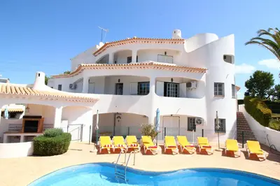 a large white house with a swimming pool in front of it at Quinta Das Flores, Lote 9 in Albufeira