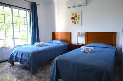 a bedroom with two beds and a large window at Quinta Das Flores, Lote 9 in Albufeira