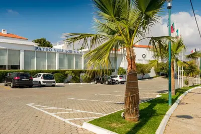 a palm tree in a parking lot in front of a building at Pateo Village in Albufeira