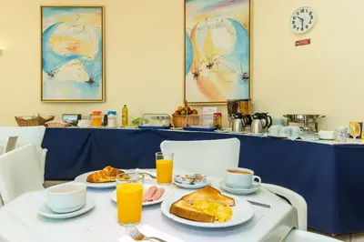 a table with a breakfast of toast and orange juice at Club Ouratlantico in Albufeira