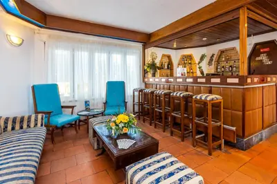 a living room with a bar and blue chairs at Hotel Mar A Vista in Albufeira