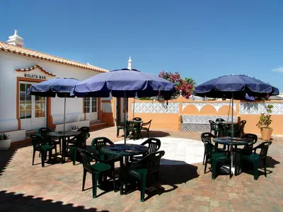 a patio with tables and chairs and umbrellas at Oleandro Country Club in Albufeira