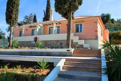 a house with a tree and stairs in front of it at Oleandro Country Club in Albufeira