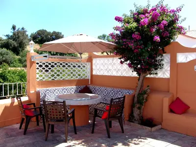 a table and chairs and an umbrella on a patio at Oleandro Country Club in Albufeira